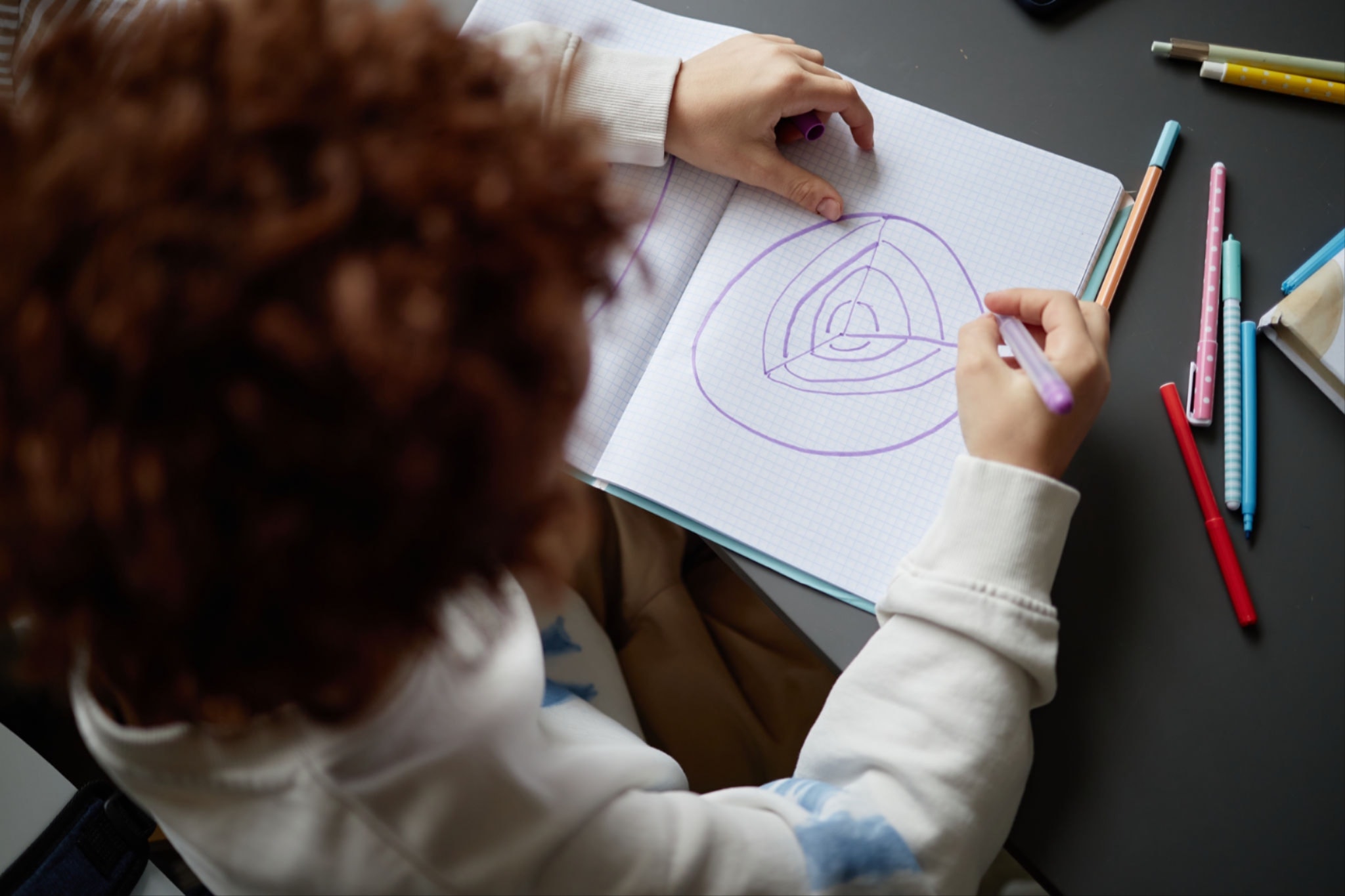 Child writing at desk in Leap Beyond preschool program